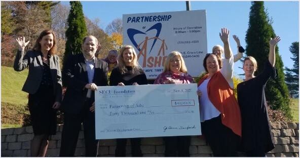 Group of people holding grant check for Partnership of Ashe